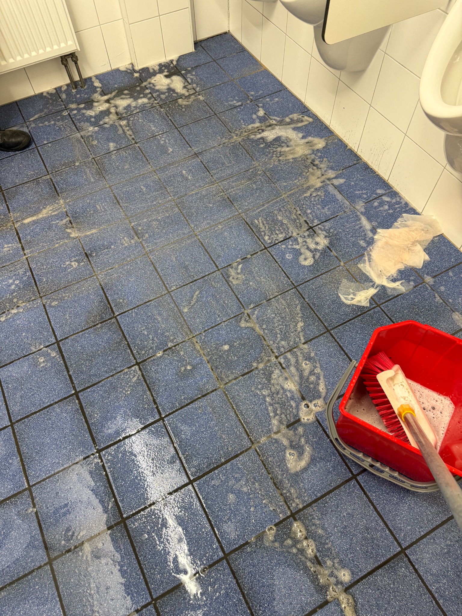 Sanitärboden mit Reinigungslösung während einer intensiven Grundreinigung